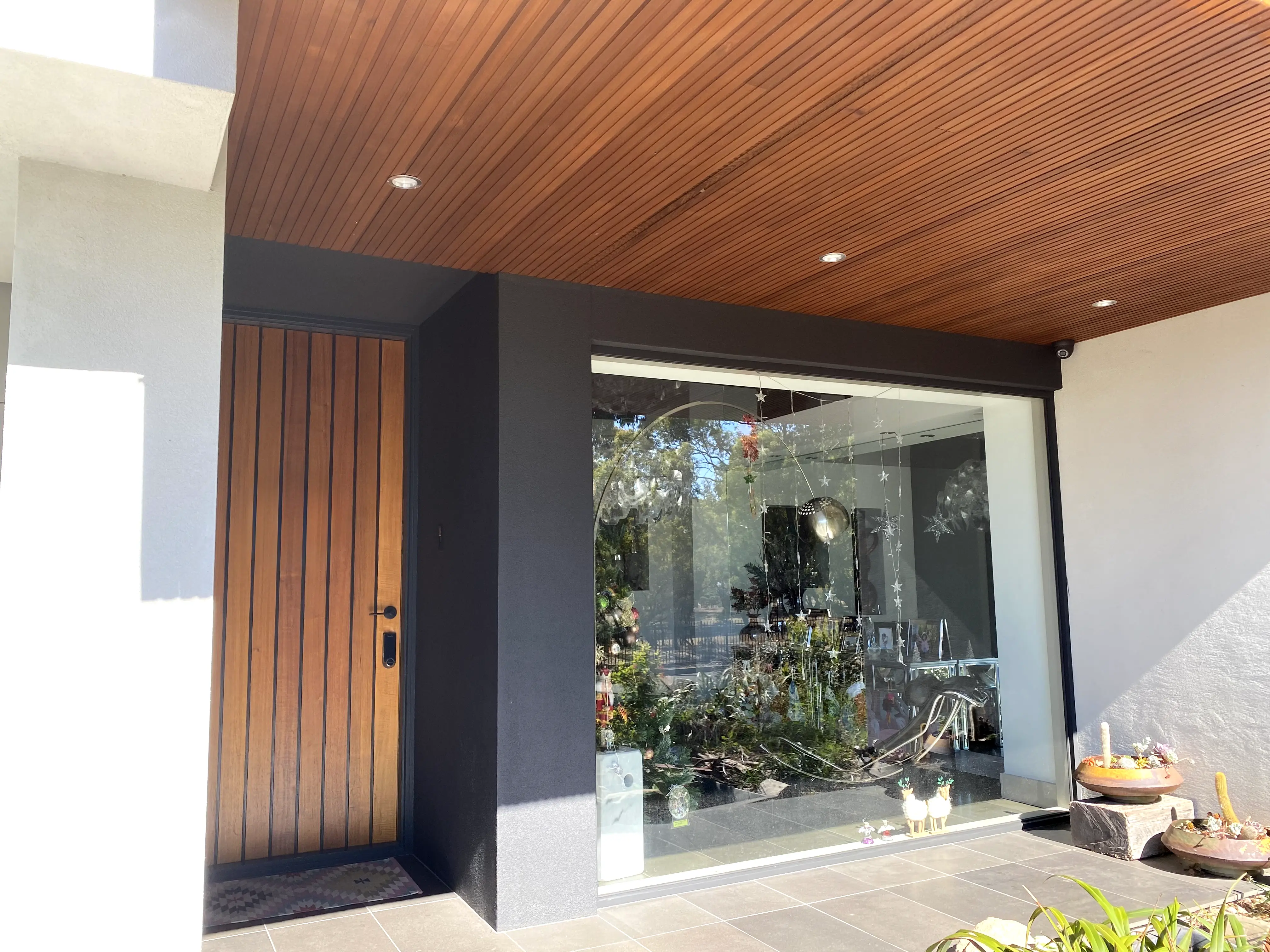 Entry with vertical timber door and timber soffit lining