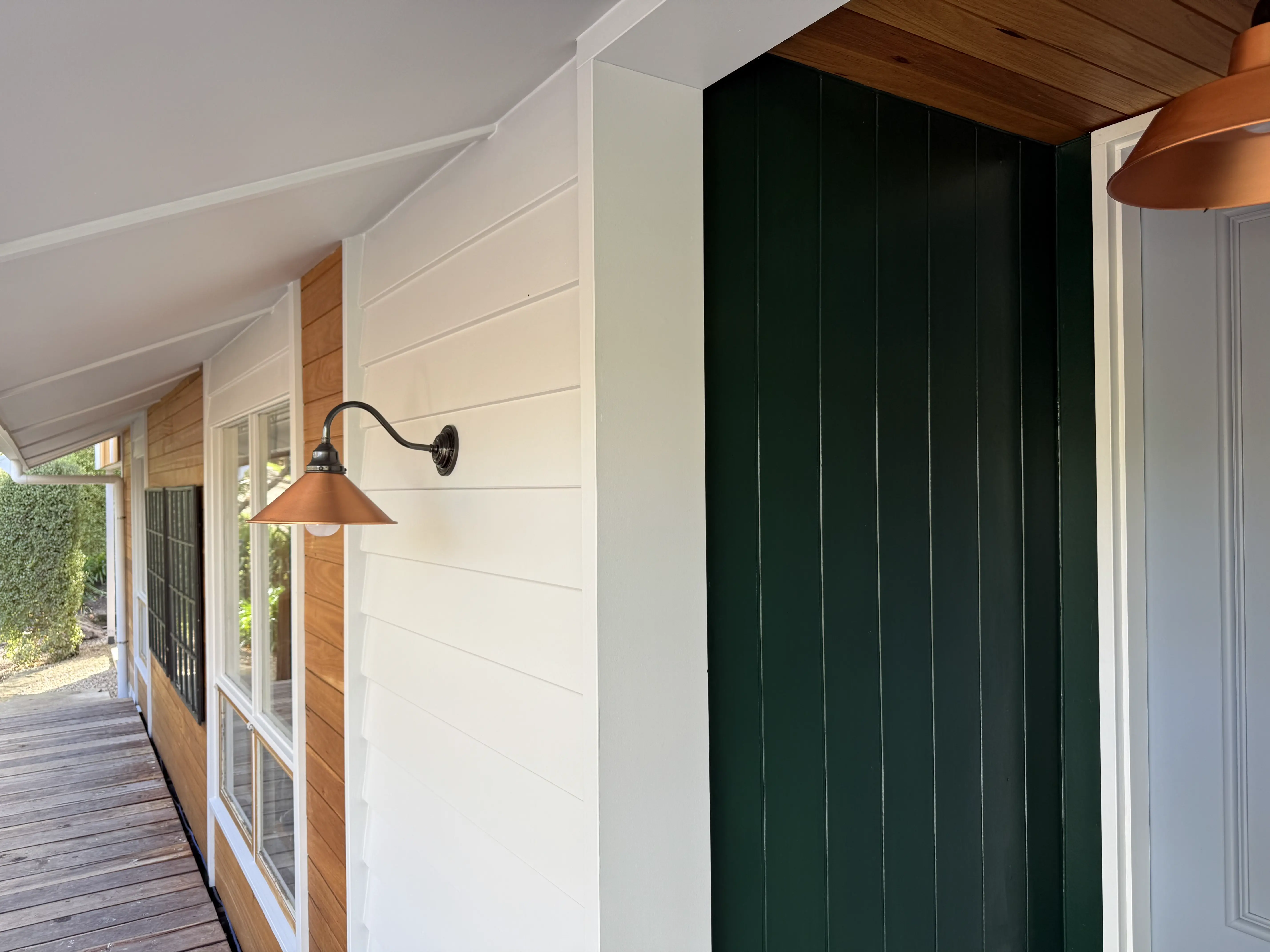 Timber cladding, white weatherboard and green entry wall